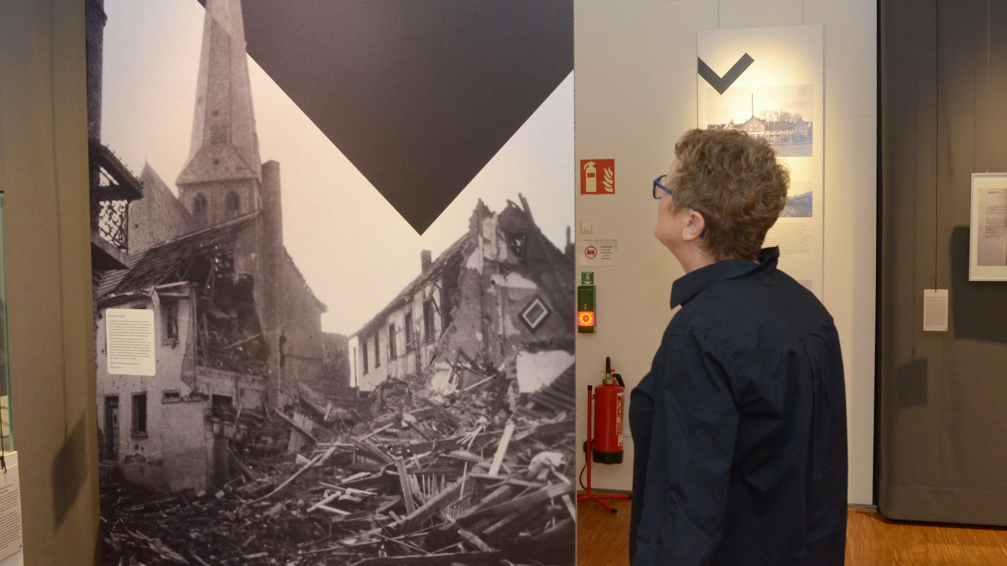 Eine Frau schaut sich im Museum ein Schwarz-Weiß-Foto an.