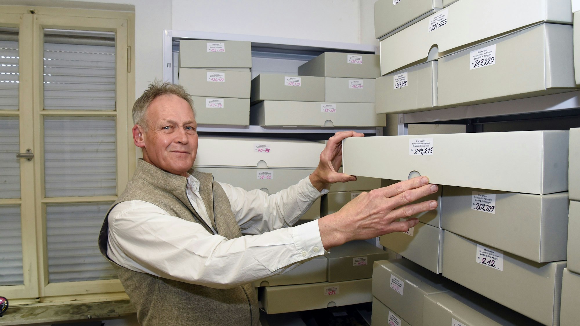 Das Foto zeigt den Heimatforscher Walfried Höller im Pfarrarchiv Hohkeppel.