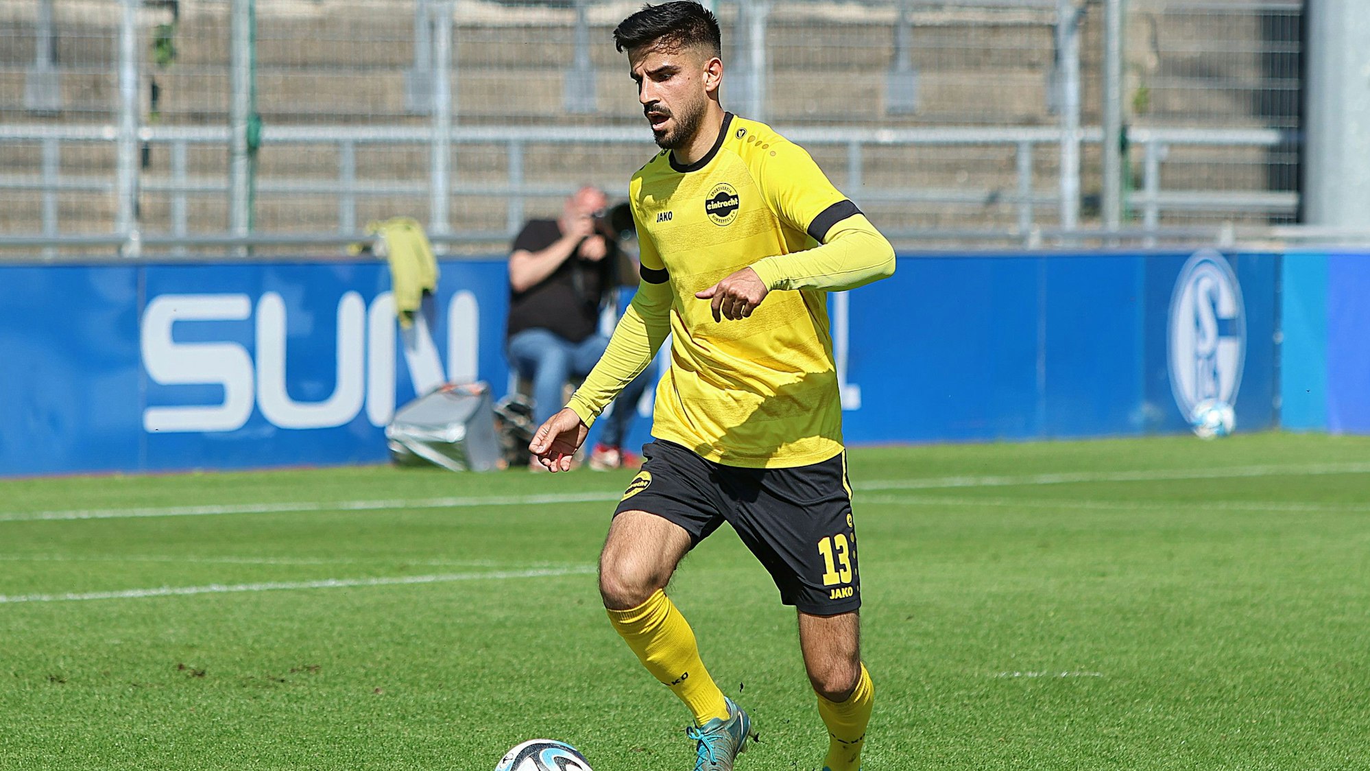 Zu sehen ist ein Fußballspieler, der mit dem Ball dribbelt.