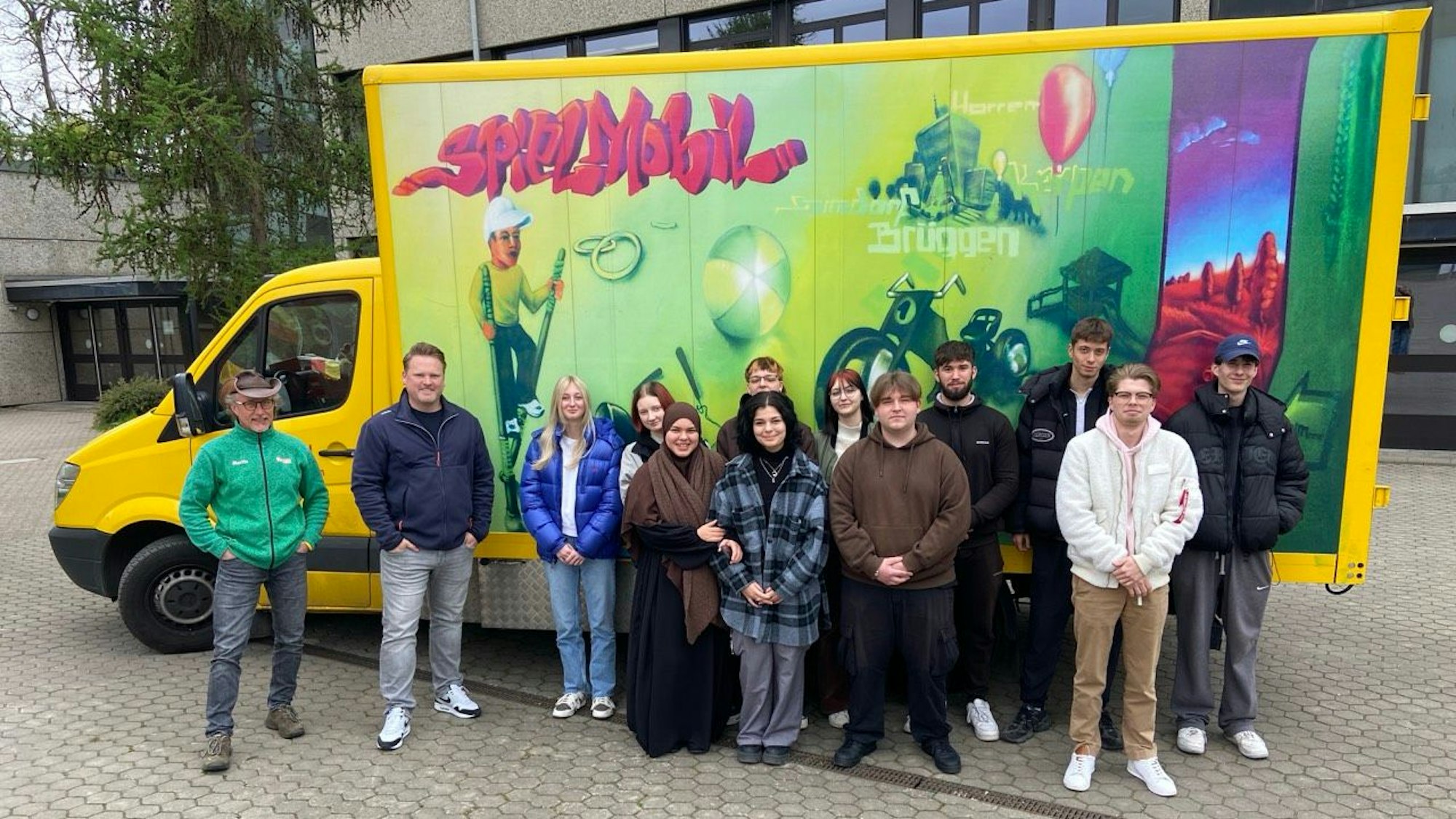 Das Foto zeigt die Mitarbeiter des Kerpener Spielmobils vor ebendiesem.