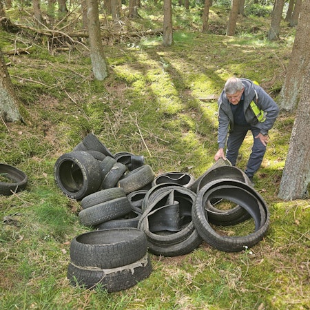 Harald Heinen beugt sich über die Reifen.