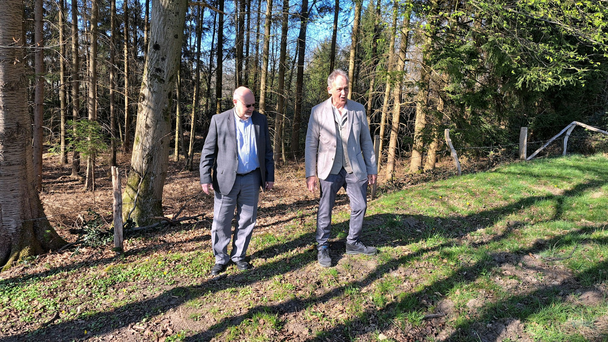 Das Foto zeigt Wolfgang Hasberg und Walfried Höller auf einer Wiese nahe Hommerich, wo die Toten zunächst verscharrt wurden.