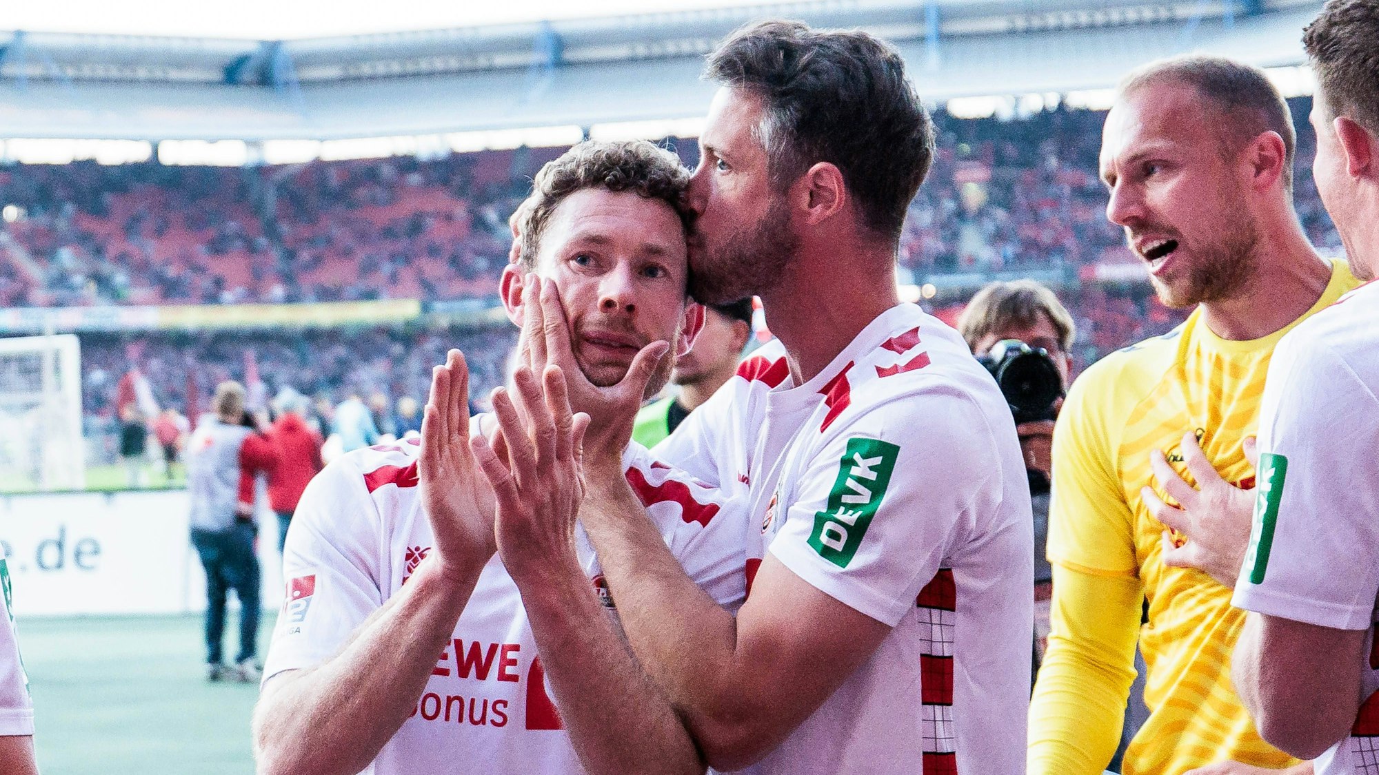 Die Mannschaft des 1. FC Köln feiert den Sieg mit den Fans. Florian Kainz wird von Mark Uth (r.) geküsst.