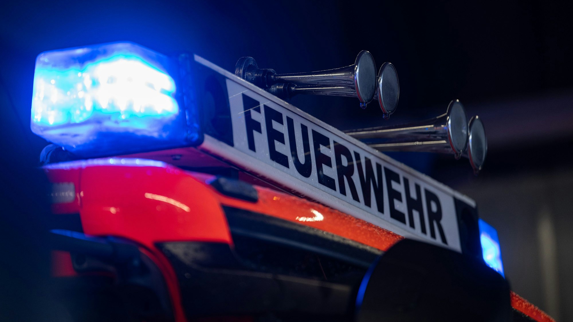Ein Einsatzfahrzeug der Feuerwehr steht mit Blaulicht bei der Feuerwache.
