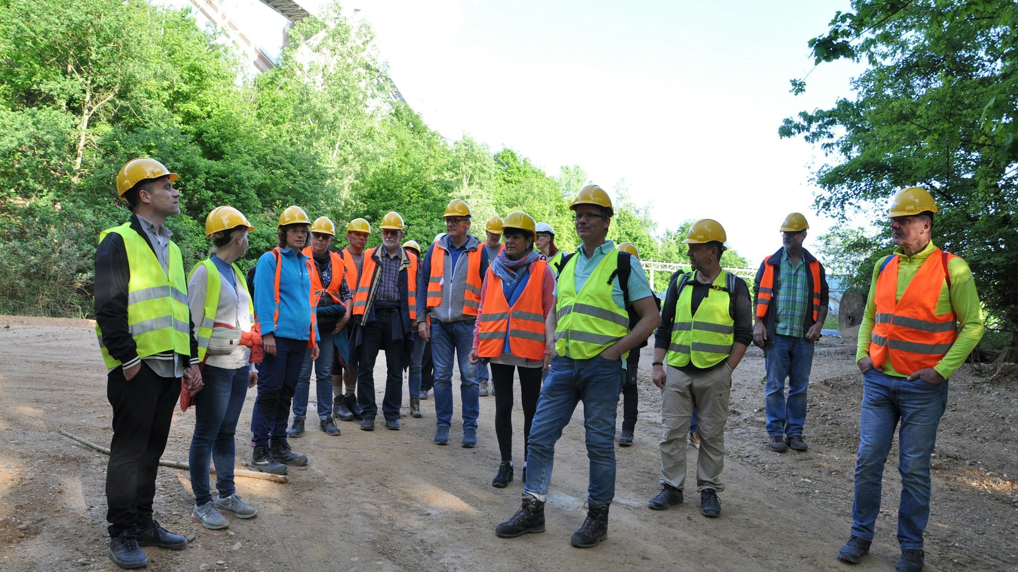 Die Besucher der Führung tragen Warnwesten und gelbe Helme.