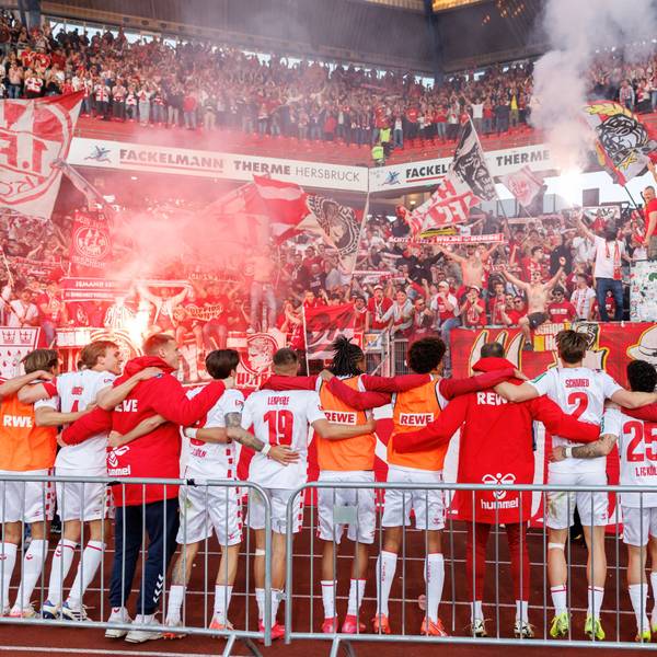 Kölner Zusammenhalt: Die FC-Spieler stehen nach dem 2:1 in Nürnberg Arm in Arm vor der Fankurve.