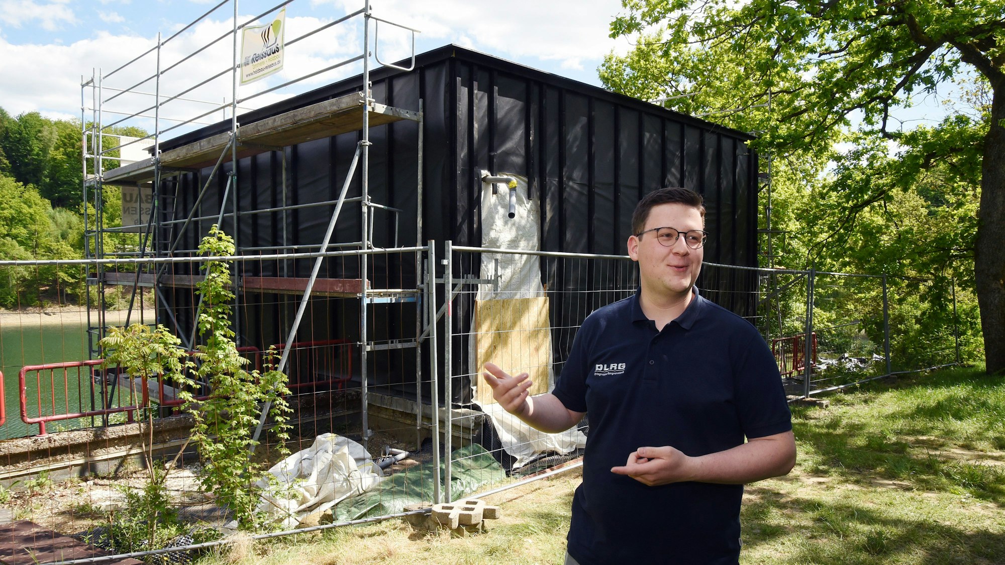 Ein Mann steht vor dem Neubau einer neuen Wasserrettungsstation.