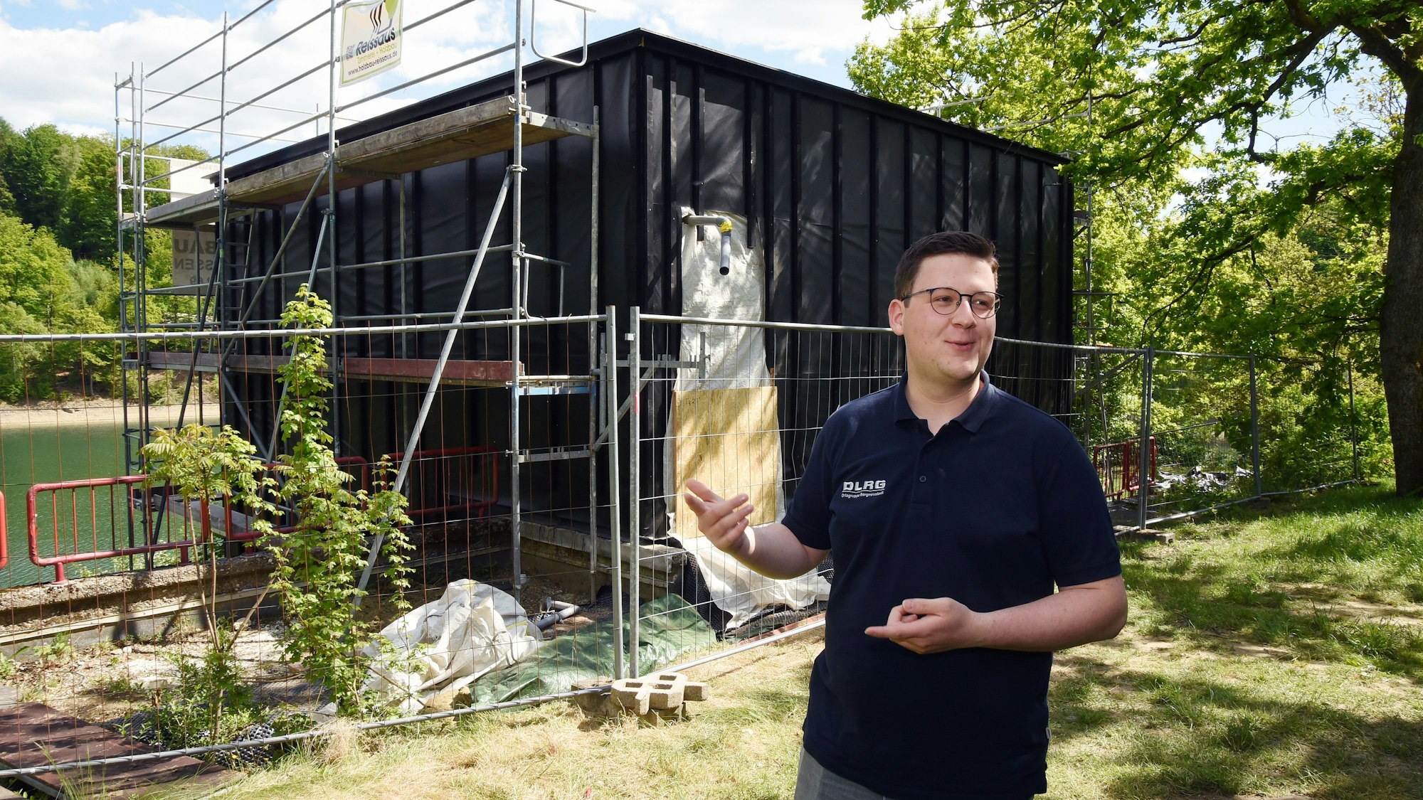 Das Foto zeigt den halbfertigen Neubau der Station, davor steht Philip Solbach von der DLRG.