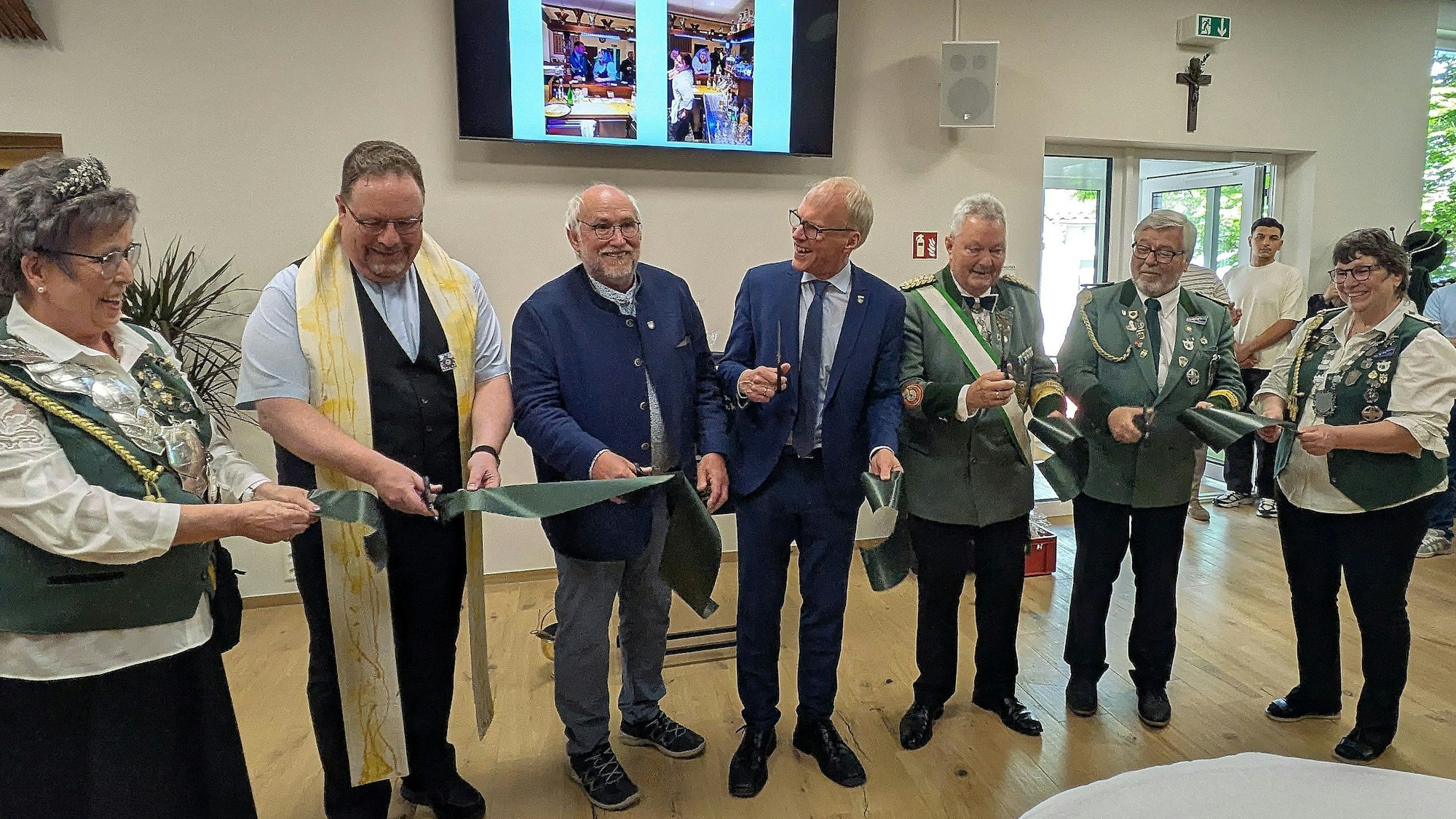 Das grüne Band zur Wiedereröffnung der Schützenhalle der Rheinbacher Bruderschaft wird feierlich durchgeschnitten.