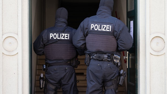 Polizisten stehen während einer Razzia gegen mutmaßliche Rechtsextreme in einem Hauseingang im Dresdner Stadtteil Cotta. (Archivbild)