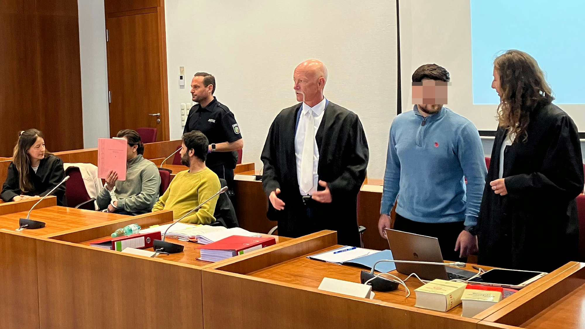 Das Foto zeigt die gepixelten Angeklagten und ihre Verteidiger.