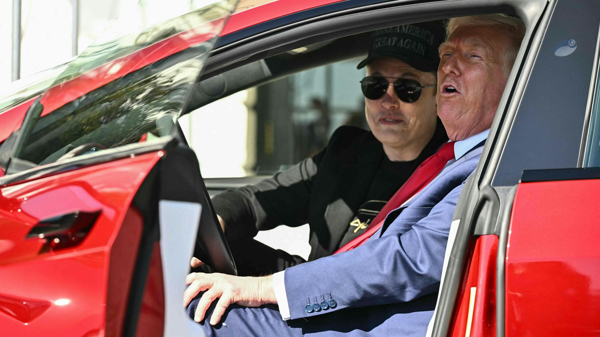 US-Präsident Donald Trump und Tesla-Chef Elon Musk sprechen mit der Presse, während sie in einem Tesla-Fahrzeug auf der Südseite des Weißen Hauses sitzen.
