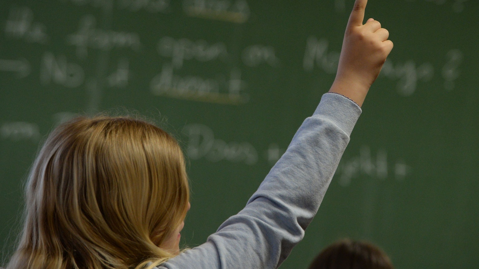 Eine Schülerin meldet sich in einem Klassenzimmer in einem Gymnasium während des Englischunterrichts.