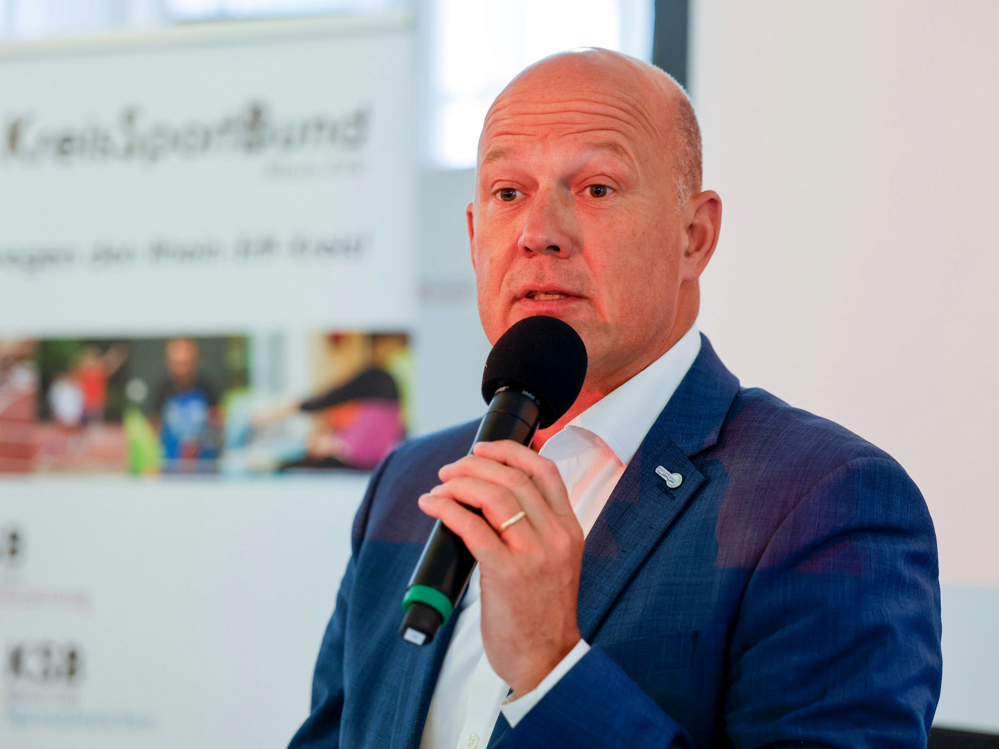 Zu sehen ist Frank Rock mit einem Mikrofon in der Hand.