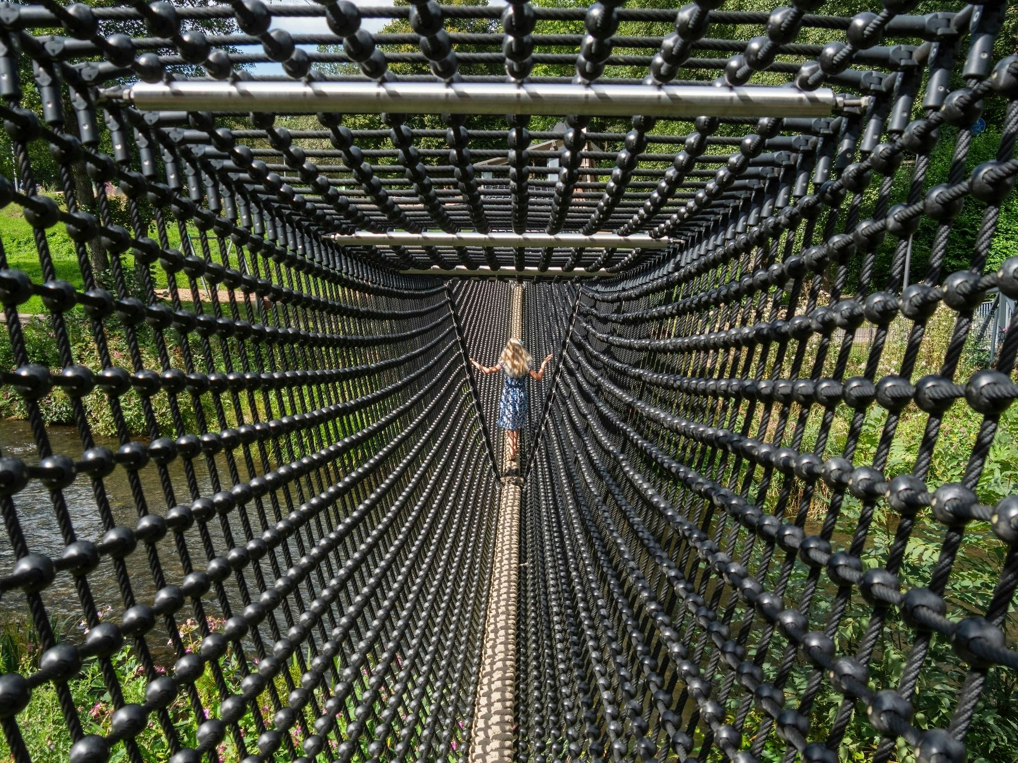 Ein Mädchen läuft in einer geschlossenen Hängebrücke.