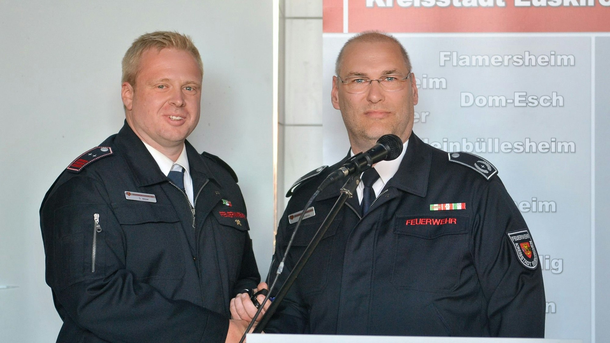 Bei der Einweihung des Feuerwehrgerätehauses Wüschheim stehen die beiden Feuerwehrmänner in blauer Uniform am Rednerpult.