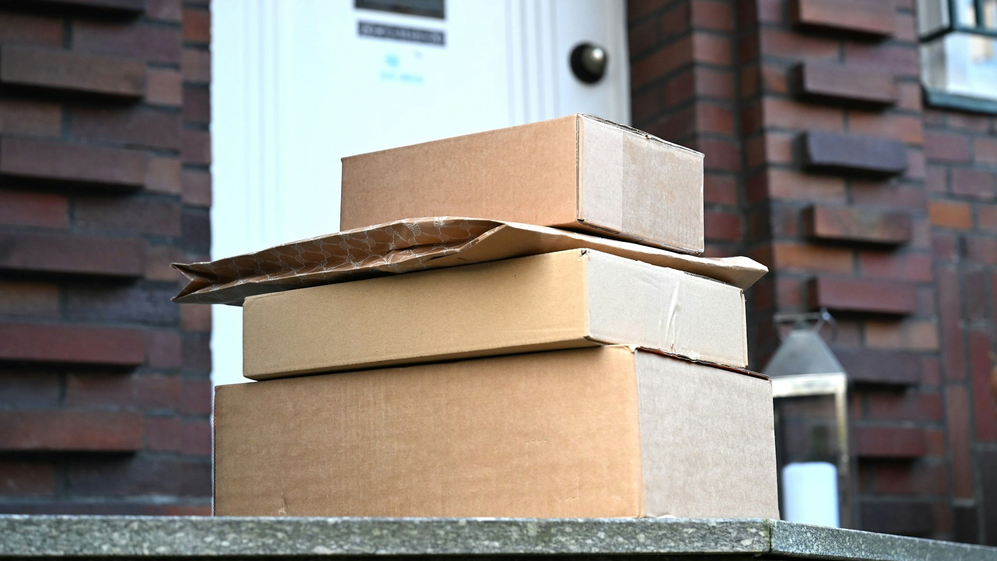 PRODUKTION - 15.03.2025, Nordrhein-Westfalen, Düsseldorf: Vier von einem Paketboten gebrachte Pakete liegen vor einer Haustür. Der Empfänger hatte vorher online zugestimmt, dass der Paketbote sie an einem Ablageort - in diesem Fall die Haustür - liegenlässt. Bei manchen Sendungen geht etwas schief, hunderttausende Bundesbürger haben sich im vergangenen Jahr wegen Beschädigungen, Verspätungen oder Verlusten ihrer Sendungen beschwert. (zu dpa: «Hunderttausende Beschwerden wegen Paketen und Briefen») Foto: Wolf von Dewitz/dpa +++ dpa-Bildfunk +++