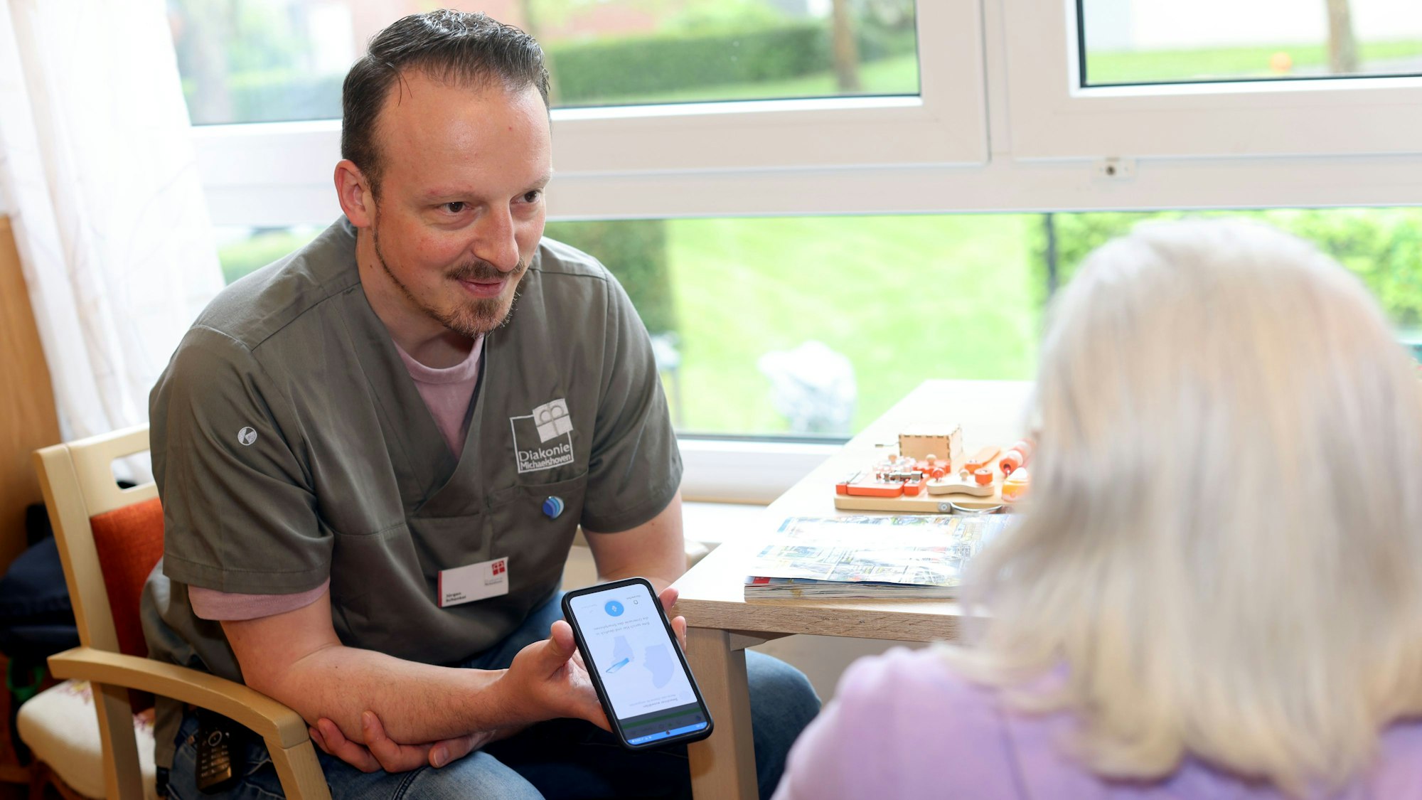 Jürgen Schenkel, Stationsleitung im Thomas-Müntzer-Haus, dokumentiert den Zustand einer Bewohnerin per Spracheingabe. Die KI macht daraufhin die richtigen Einträge in einer digitalen Akte.