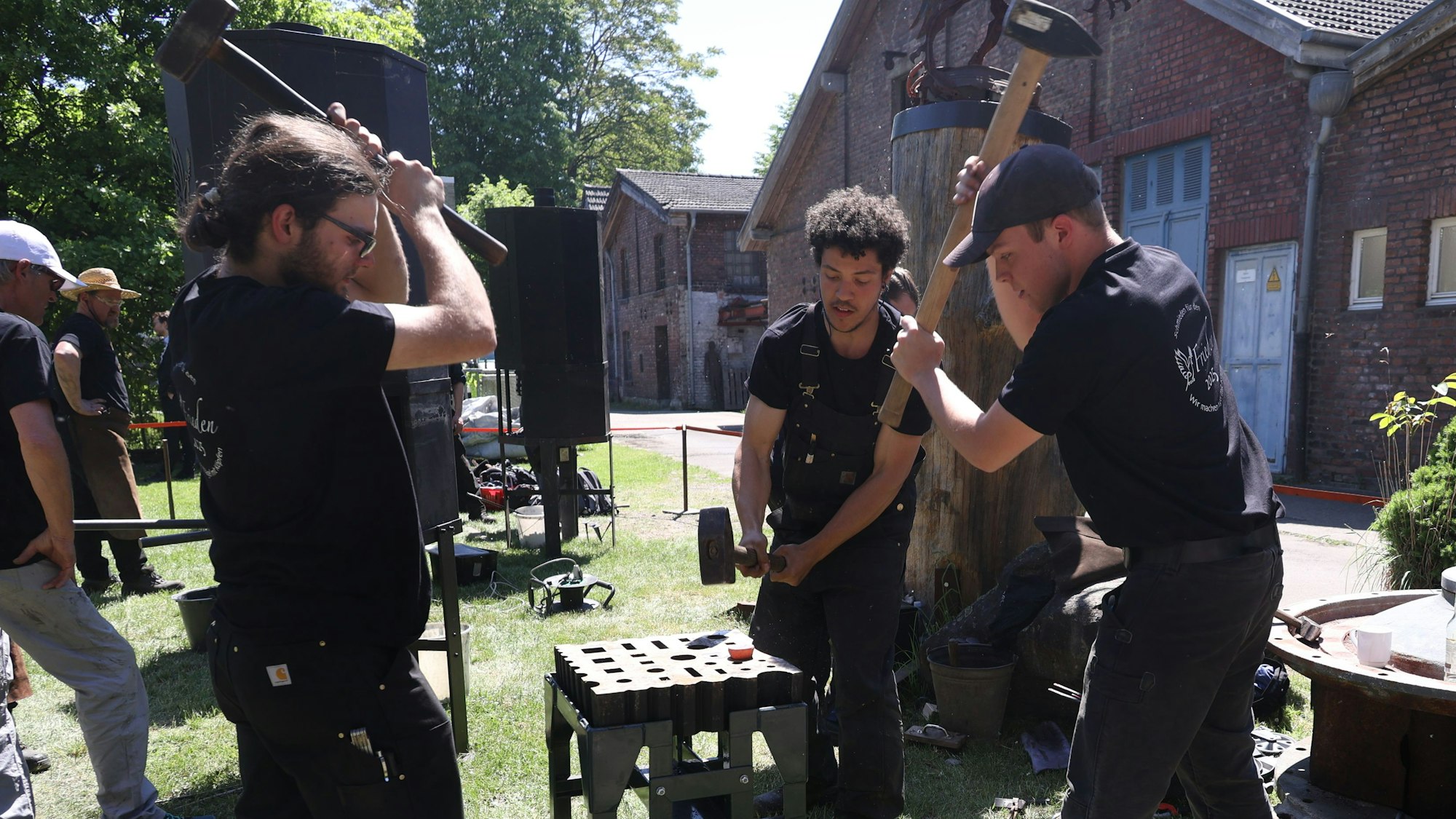 Drei Schmiede bearbeiten Eisen