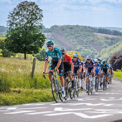 Radprofis vor einem hügeligen Panorama