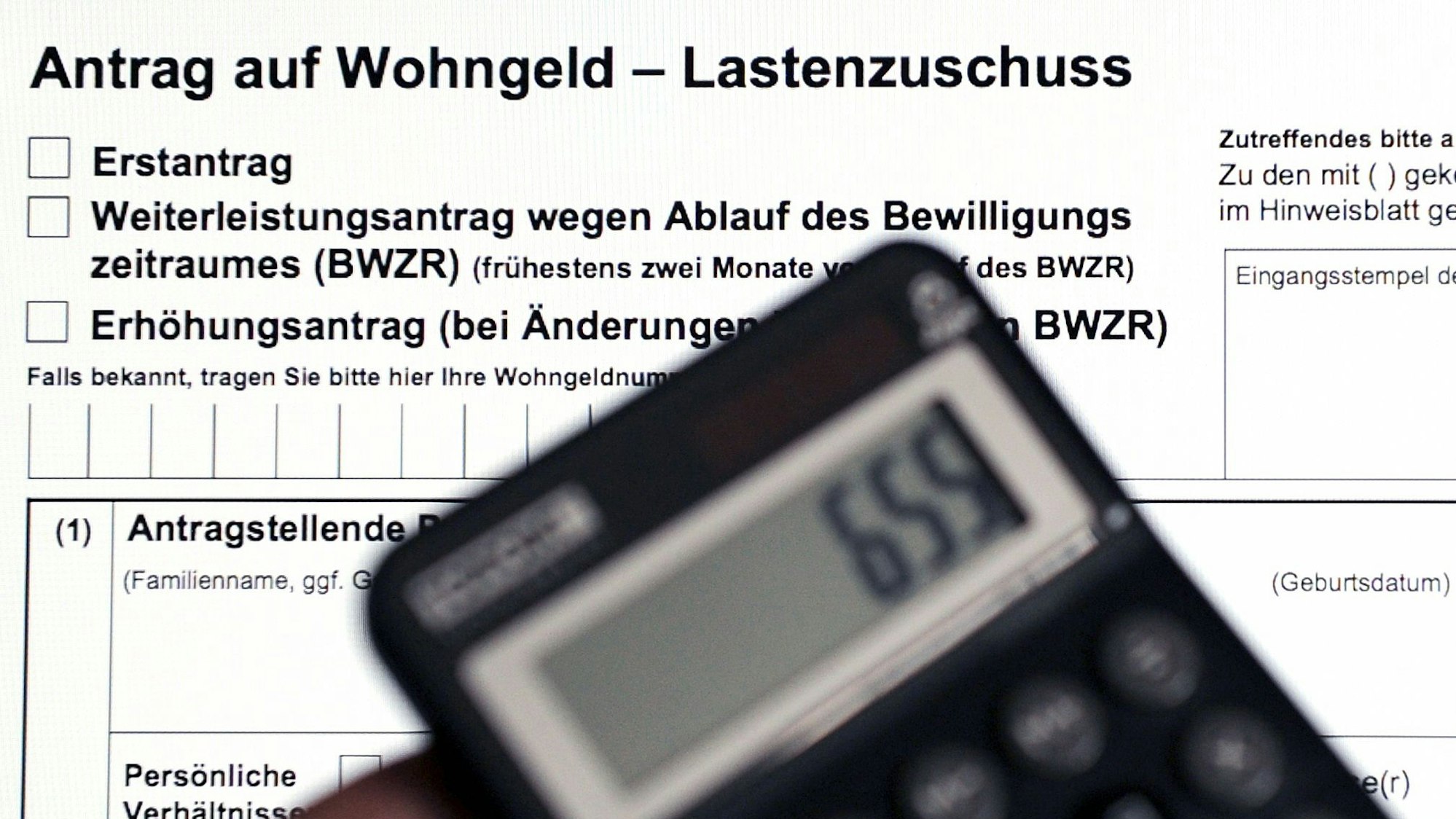Ein Wohngeldantrag auf dem Bildschirm eines Laptops und ein Taschenrechner.