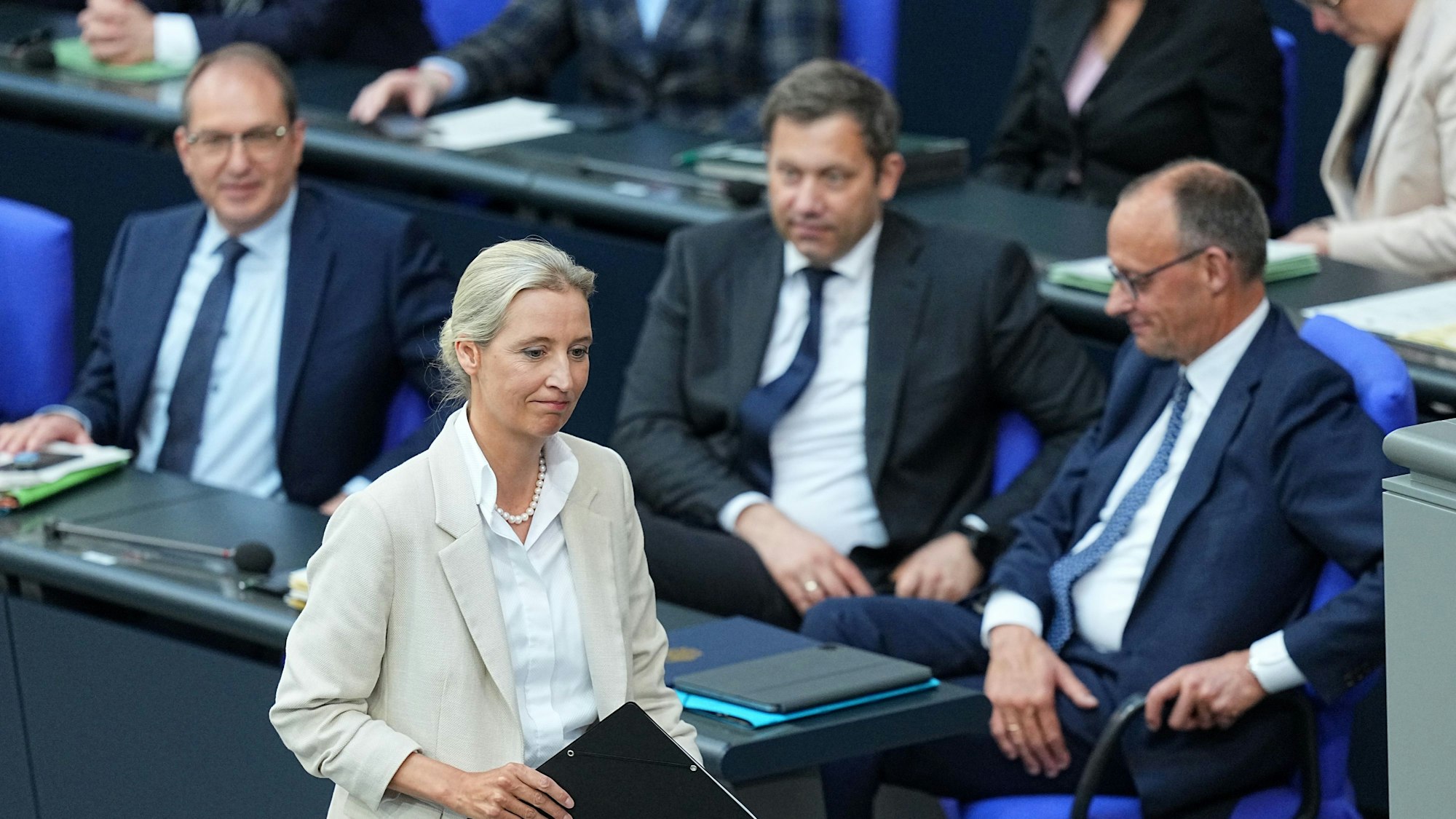 Alice Weidel geht nach der Regierungserklärung zum Rednerpult. Im Hintergrund sitzen Bundeskanzler Friedrich Merz, Lars Klingbeil und Alexander Dobrindt.