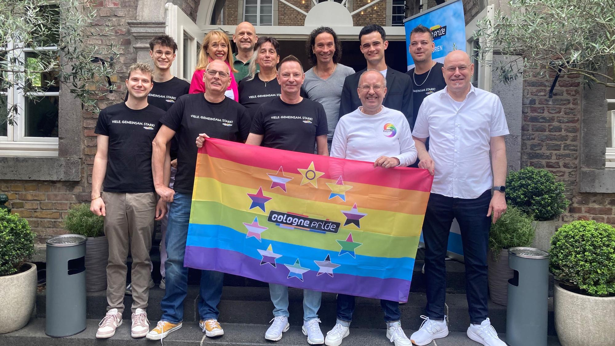 Eine Gruppe hinter dem ColognePride-Banner.