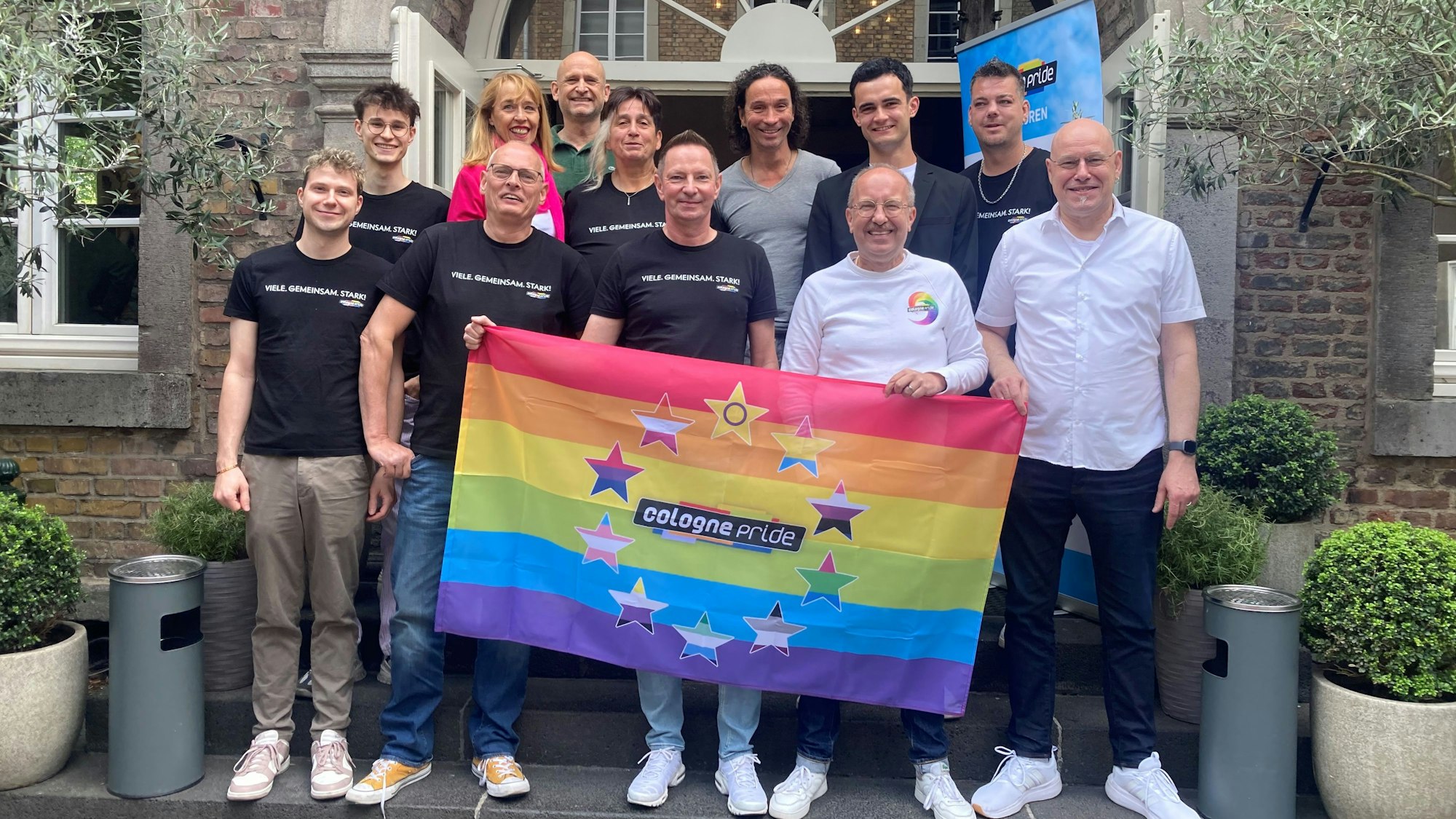 Eine Gruppe hinter dem ColognePride-Banner.