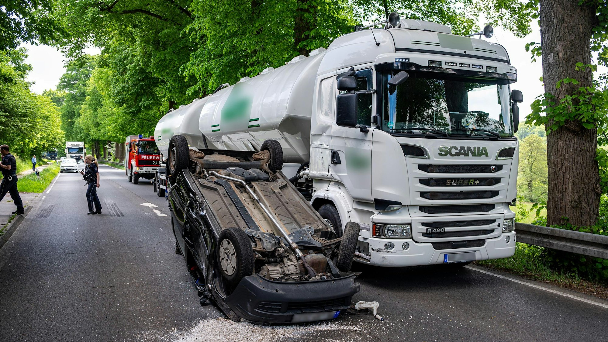 Das Foto zeigt einen Lkw und daneben einem Pkw, der auf dem Dach liegt