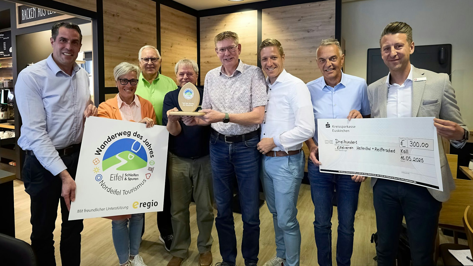 Gruppenbild für die Presse. Der Preis für den Wanderweg des Jahres sowie einen Siegerscheck halten die Laudatoren in die Luft.