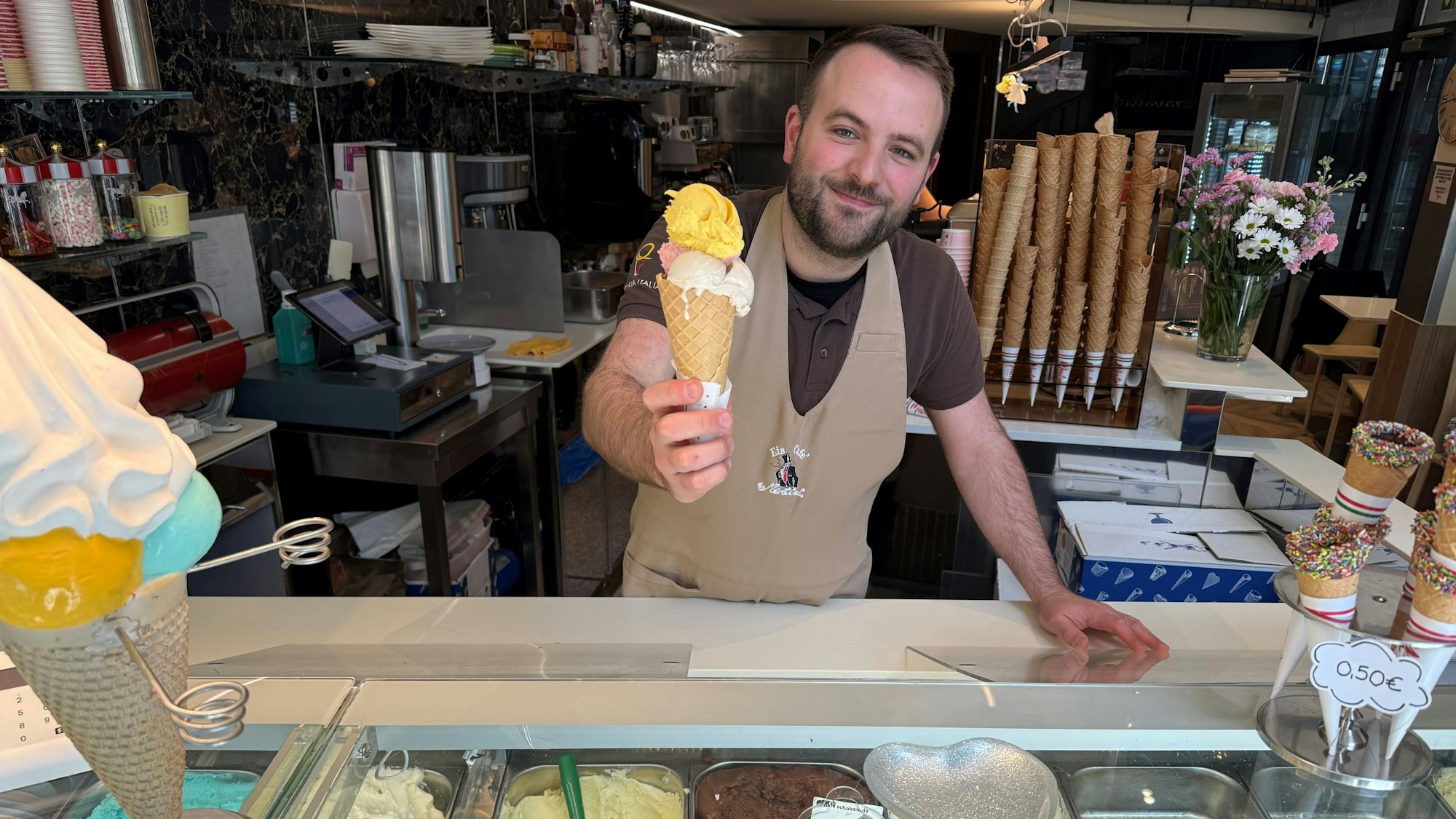Alessandro Martini übergibt ein Hörnchen mit Eis an seiner Eisdiele