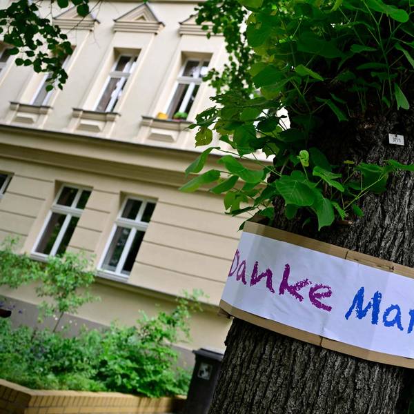 Ein Schild mit der Aufschrift „Danke, Margot“ hängt an einem Baum in Berlin.