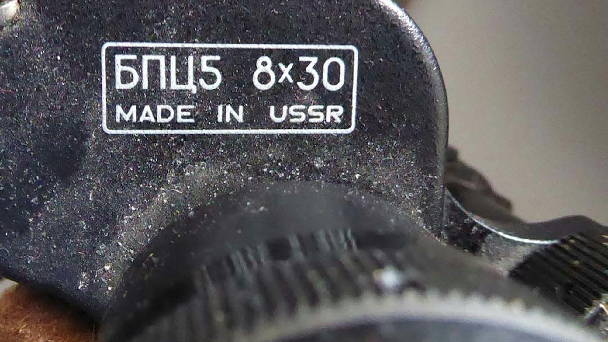 Das Bild zeigt ein Fernglas. Ein Teil der Aufschrift lautet „8x30 Made in USSR“.