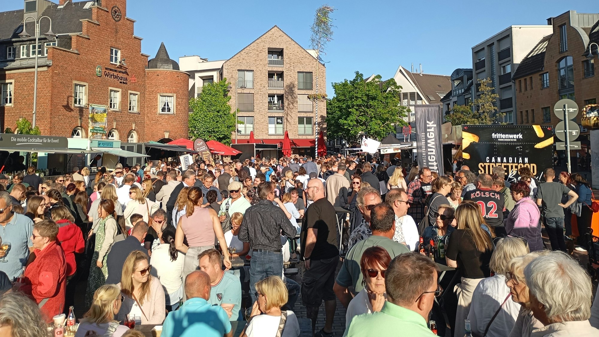 Eine Menschenmenge auf einem Marktplatz, die Leute stehen dicht an dicht.