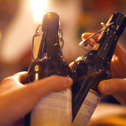 Zwei Händen mit Bierflaschen beim Anstoßen.