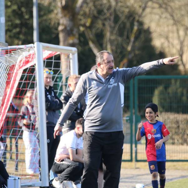 Das Bild zeigt Dirk Scheer am Spielfeldrand. Er gibt eine taktische Anweisung.