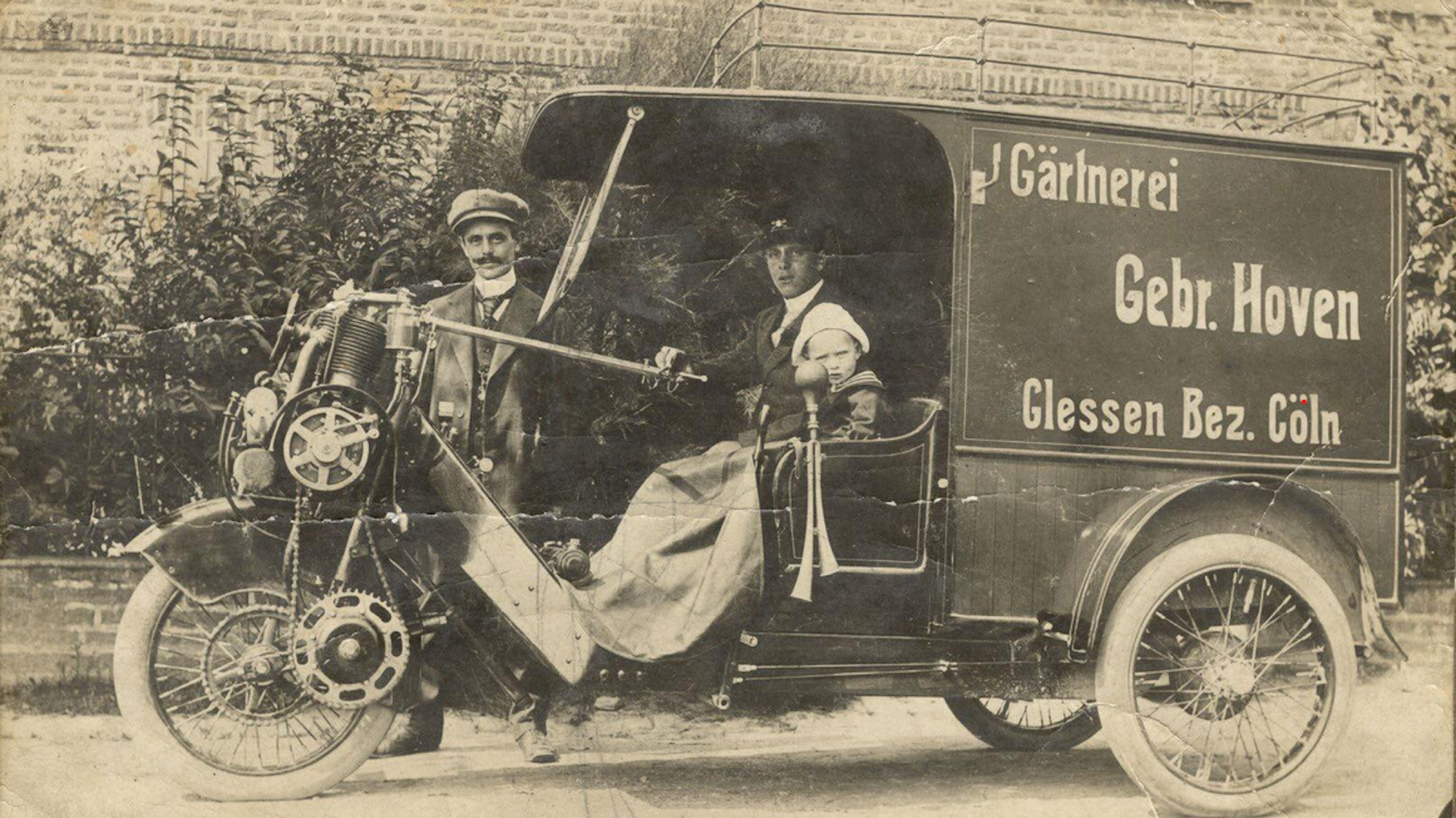 Das Bild zeigt ein älteres Fahrzeug mit der Aufschrift Gärtnerei Gebr. Hoven. Gelssen Bez. Cöln.