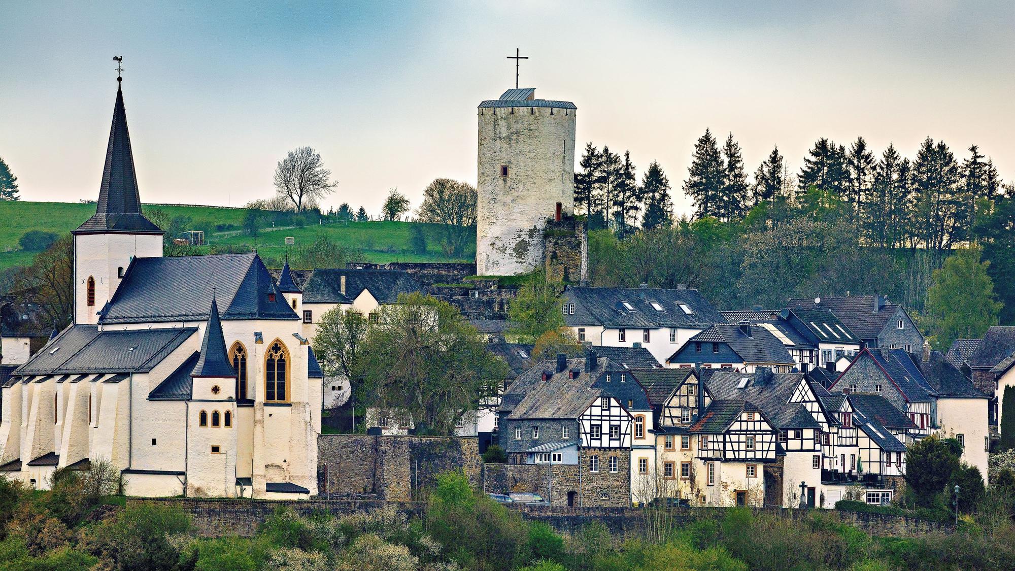 Blick auf das Dorf Reifferscheid mit Kirche, Burg und alten Fachwerkhäusern.