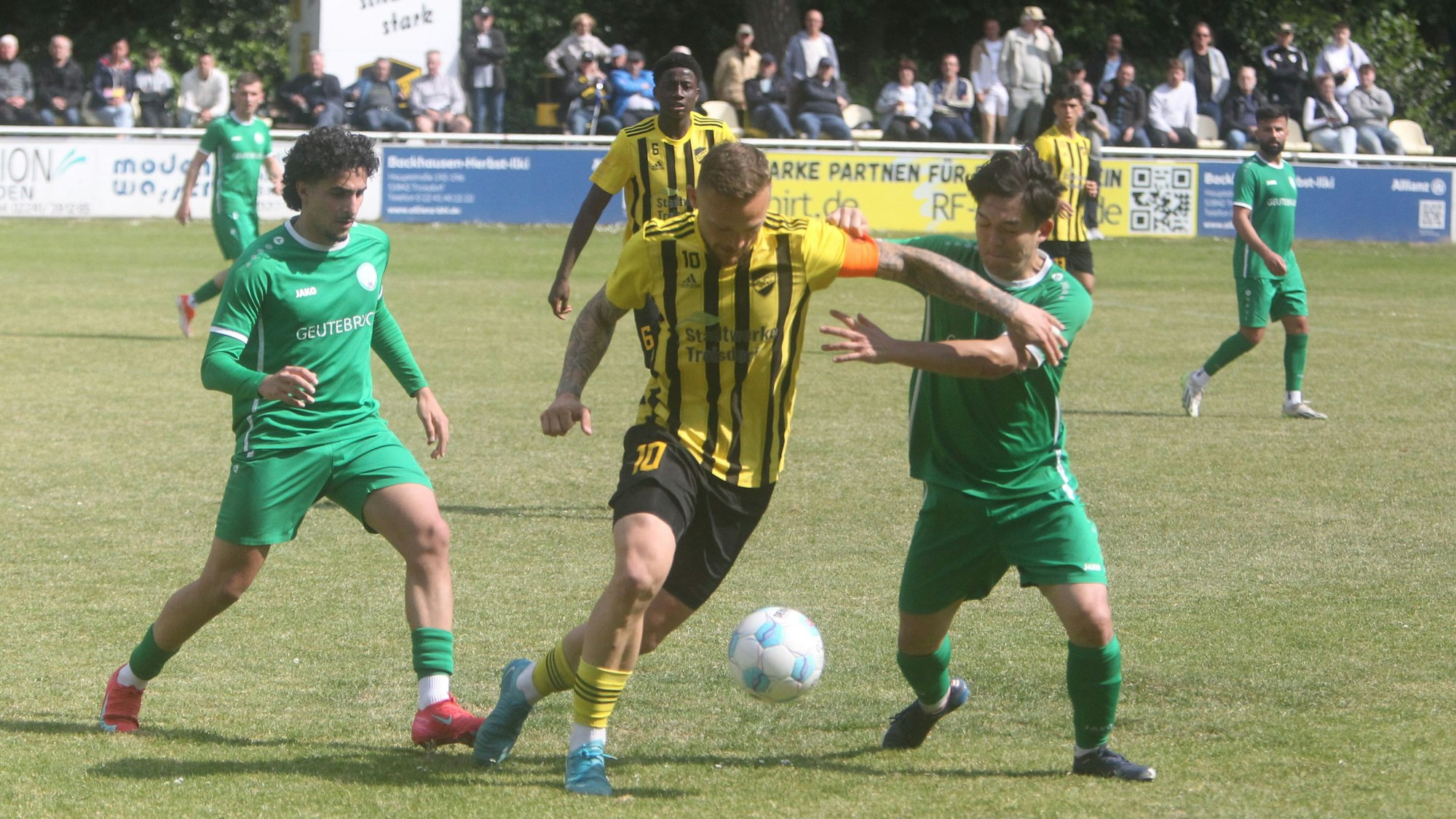 Kei Kitahara (rechts) und Sidar Simsik vom FV Bad Honnef nehmen den Spicher Kapitän Lukas Püttmann in die Zange.