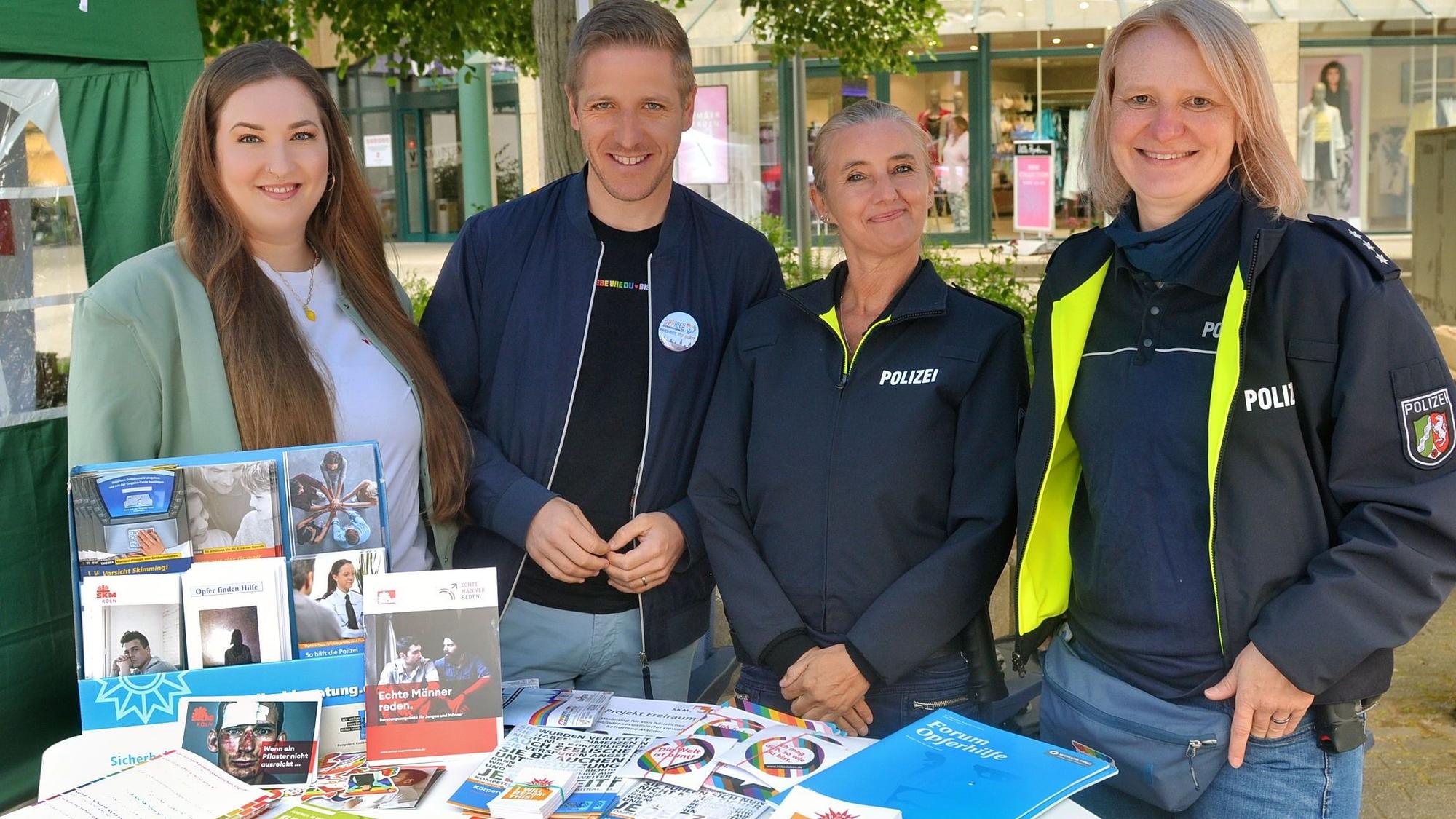 Nina Brömmelhaus, Markus Ramers, Eva Winkel und Yvonne Dederichs stehen hinter dem Infostand der Polizei.