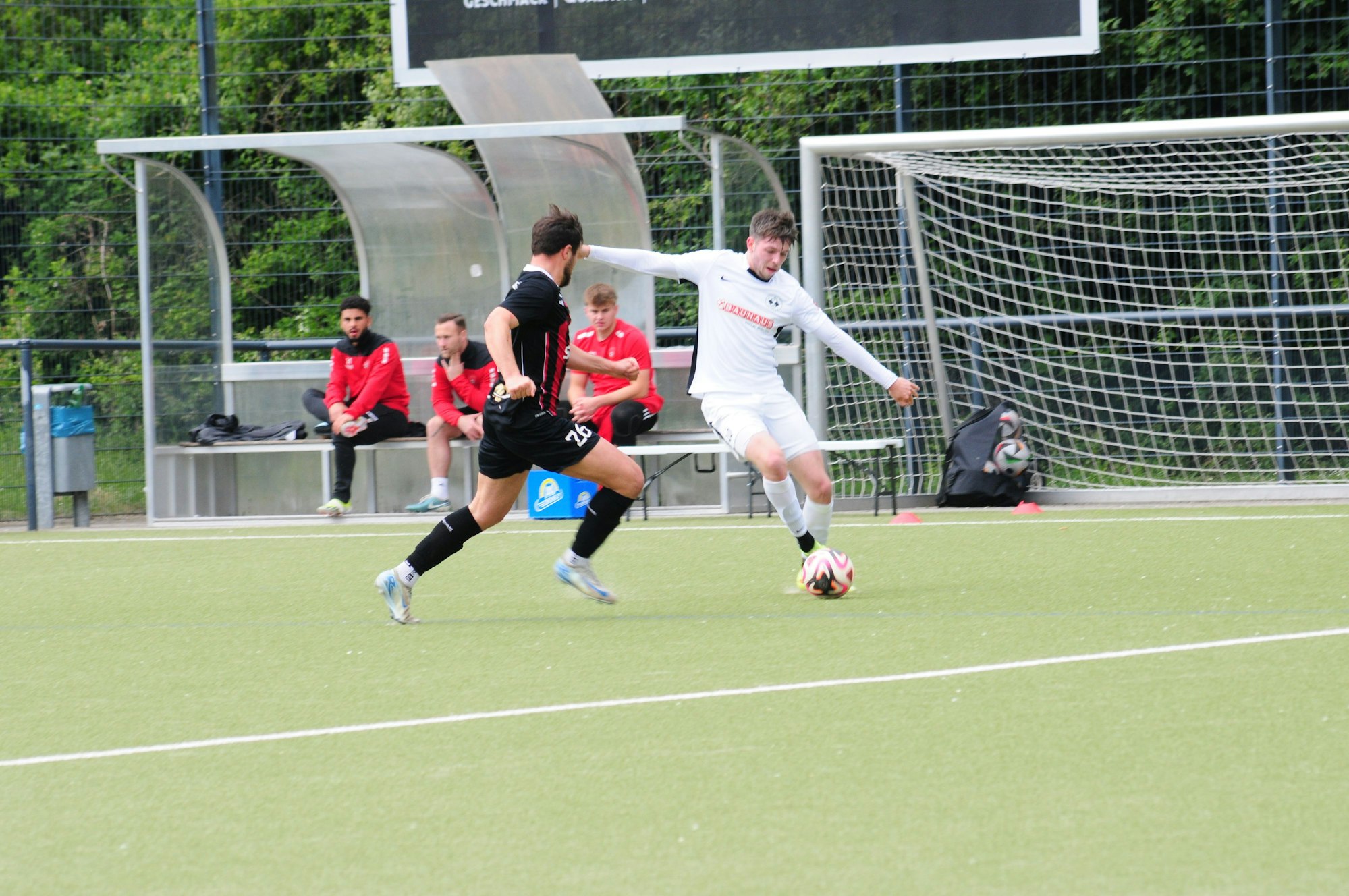 Das Bild zeigt zwei Fußball, von denen der mit dem Ball am Fuß den anderen umkurvt.