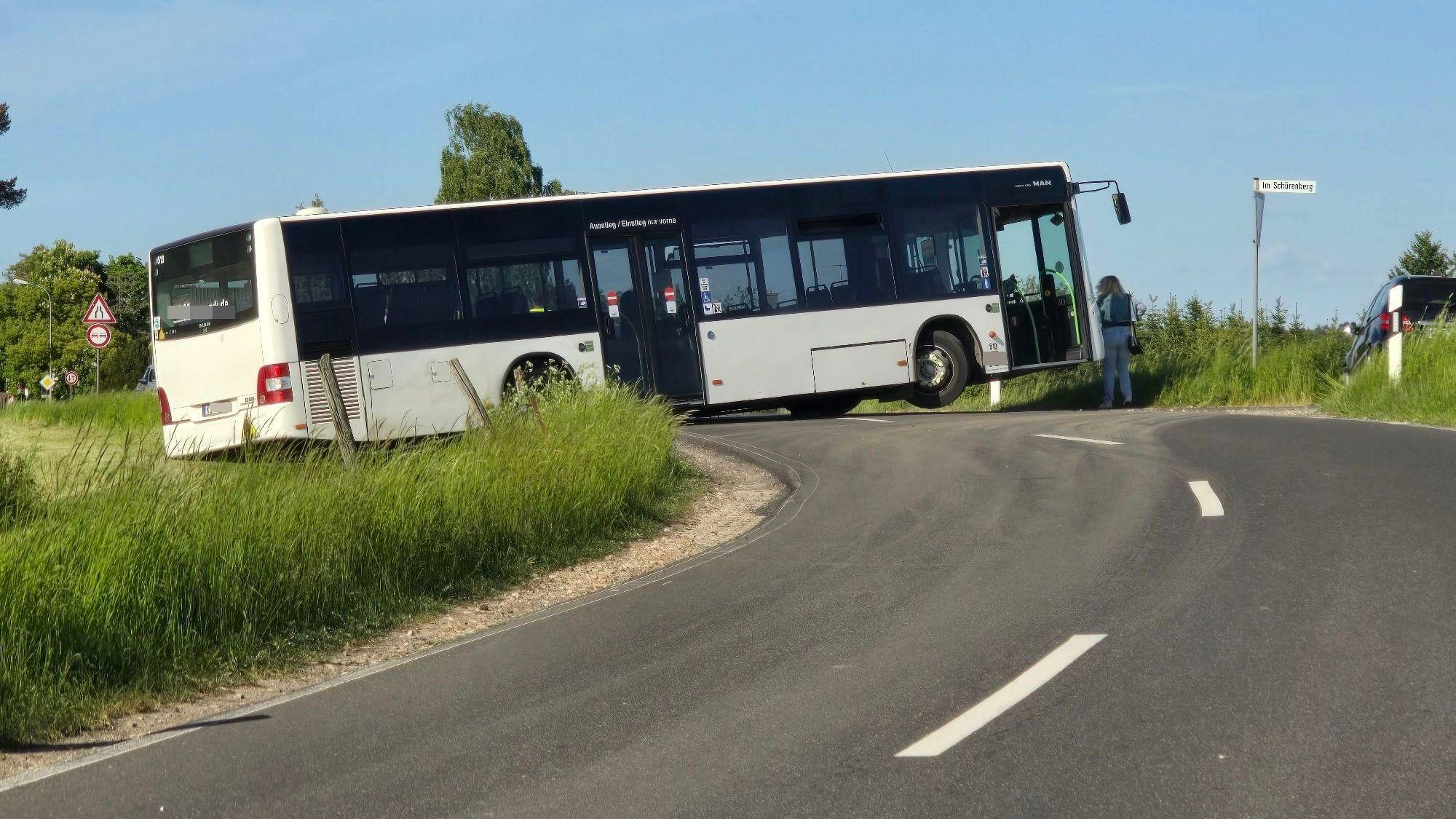 In einer Kurve steht ein Bus und versperrt die ganze Straße. Das rechte Vorderrad ist vom Boden abgehoben.