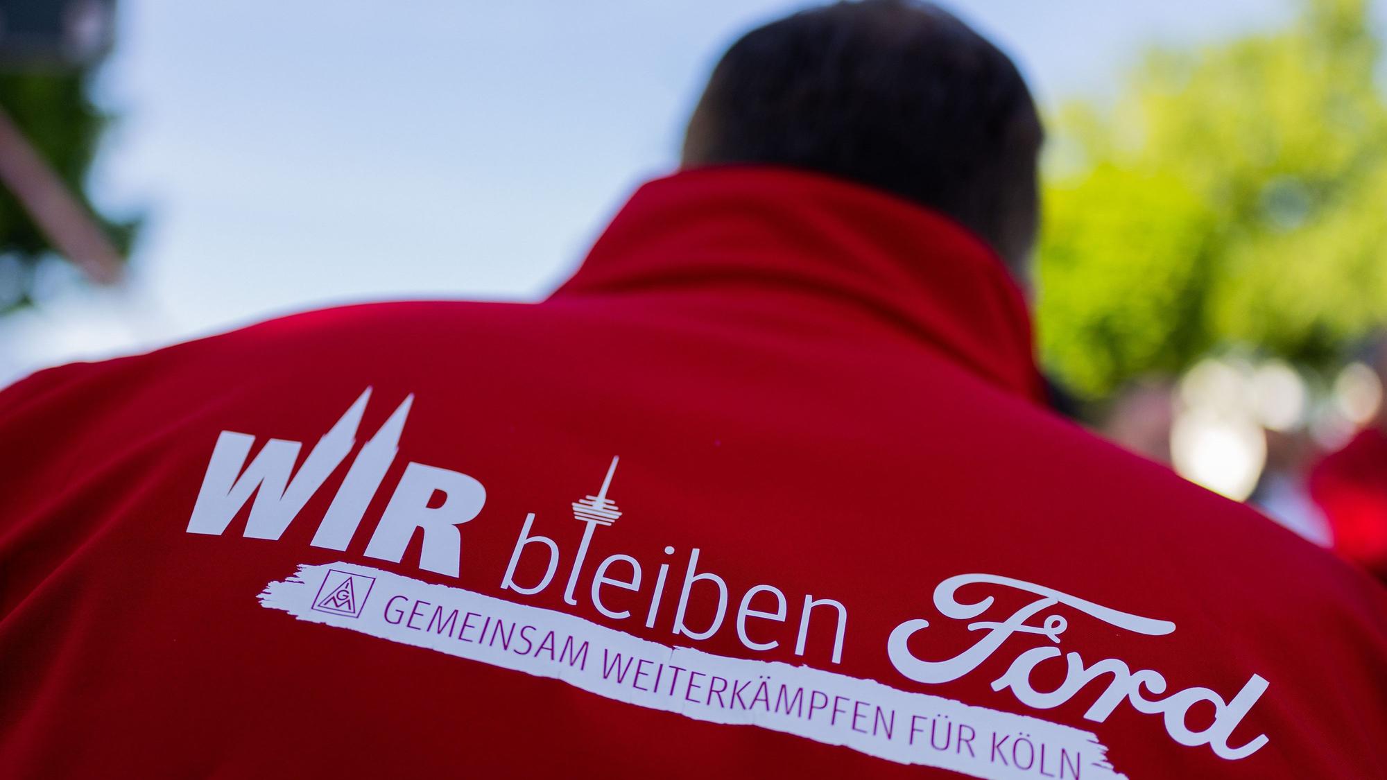 Ein Mitarbeiter trägt bei einem Streik eine Jacke mit der Aufschrift „Wir bleiben Ford - Gemeinsam weiterkämpfen für Köln“. Weitere Streiks rund u die Verhandlungen für einen Sozialtarifvertrag sind vorerst vom Tisch.
