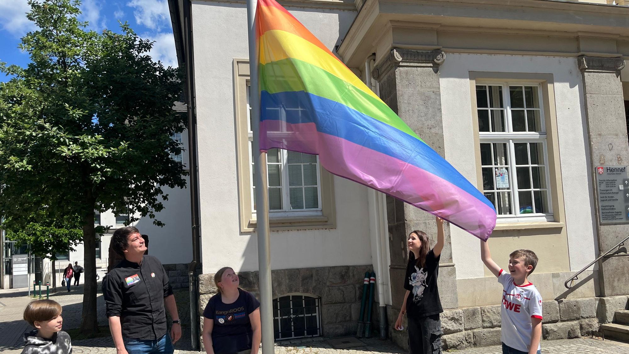 Der Windstoß kam zur richtigen Zeit und zeigte die volle Regenbogenfahne den Teilnehmenden.