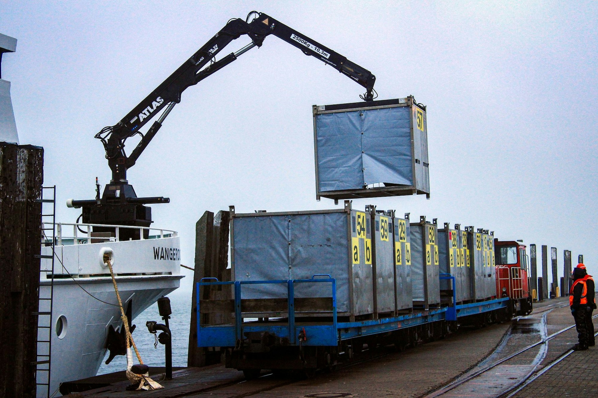 Die Gepäckcontainer werden am Hafenbahnhof vom Schiff auf die Bahn umgeladen.