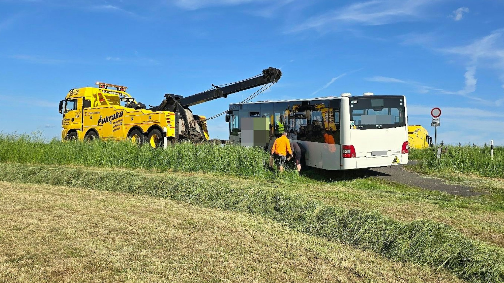 Ein Abschleppwagen steht vor dem Bus, der mit einem Stahlseil gezogen wird.