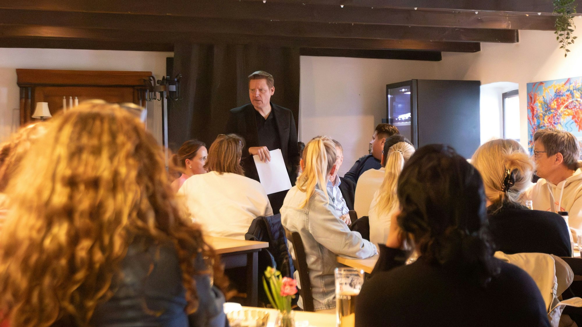 Ein Mann spricht bei einer Bürgersprechstunde vor Menschen.