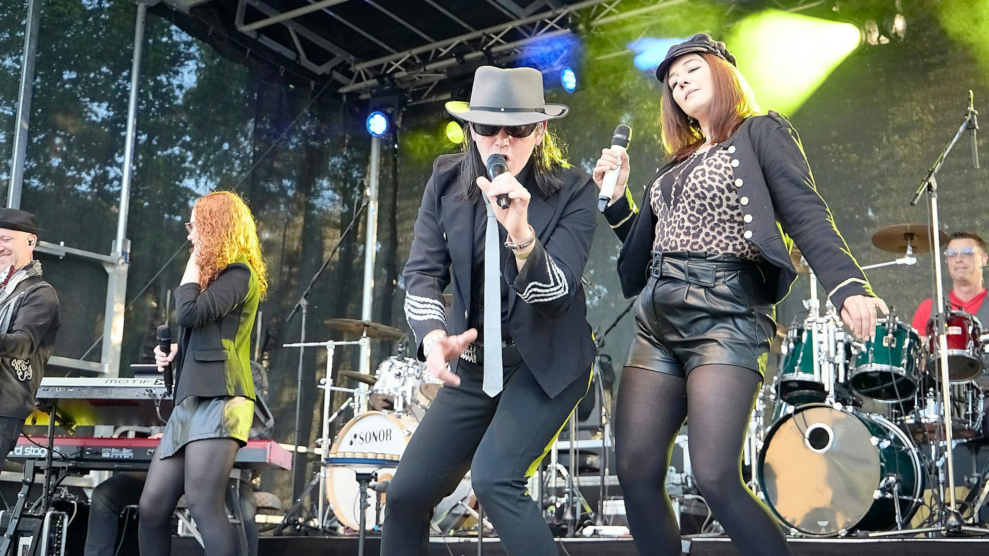 Ein Mann als Udo Lindenberg verkleidet singt in ein Mikrofon, daneben tanzt eine Frau.