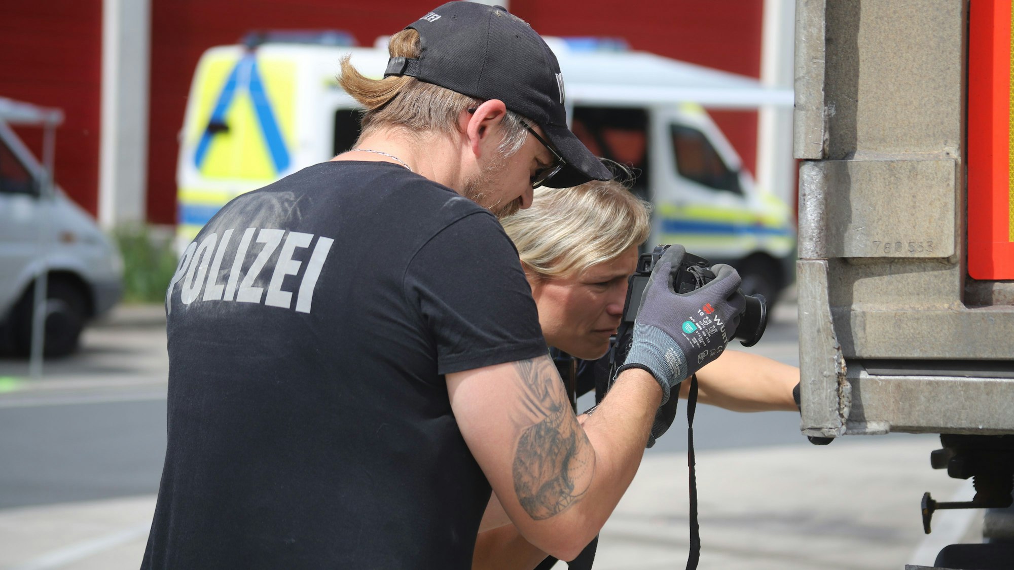 Polizisten überprüfen die Außenhaut eines Anhängers, in dem kleine Löcher zu sehen waren. Das Fahrzeug wurde stillgelegt.