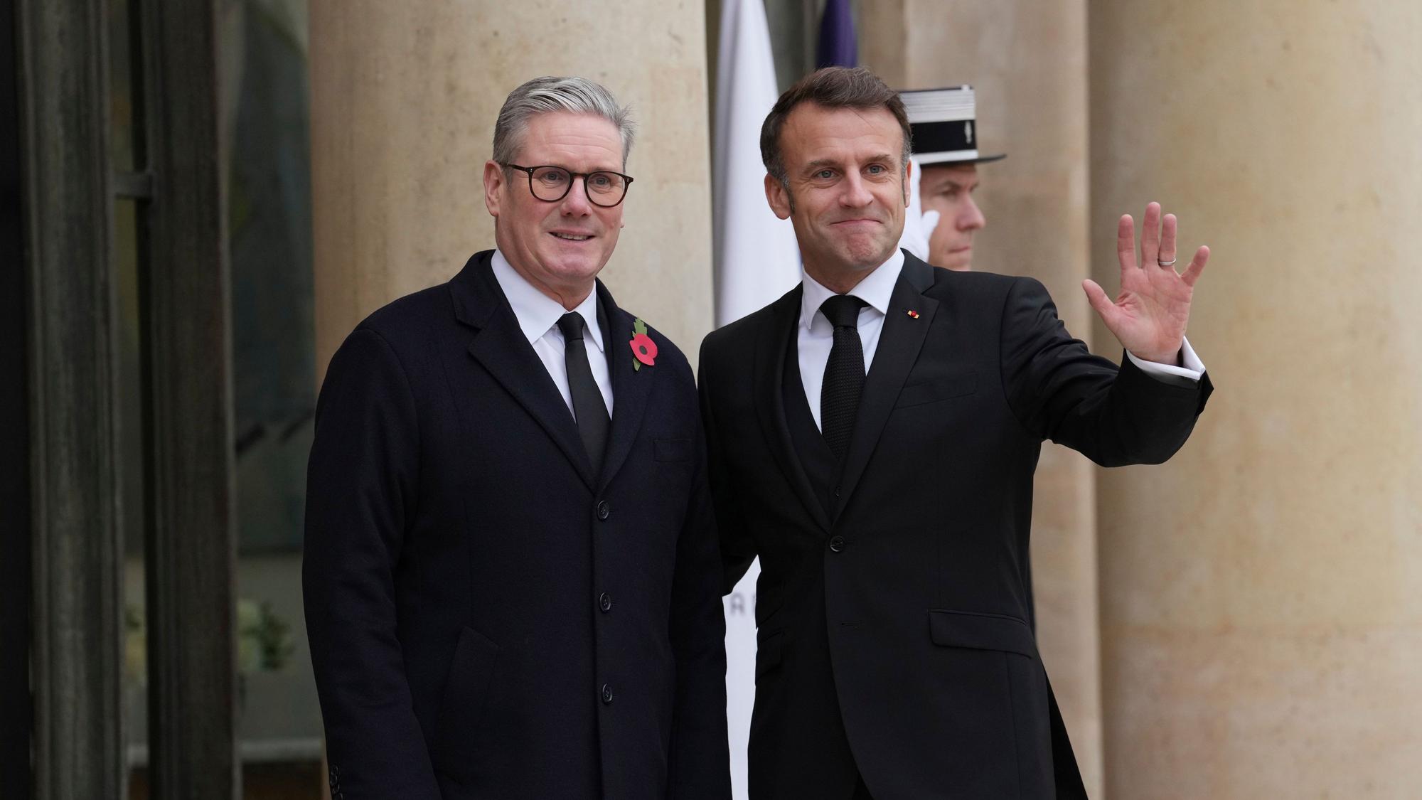 Der französische Präsident Emmanuel Macron (r) gestikuliert mit dem britischen Premierminister Keir Starmer vor dem Elysee-Palast.